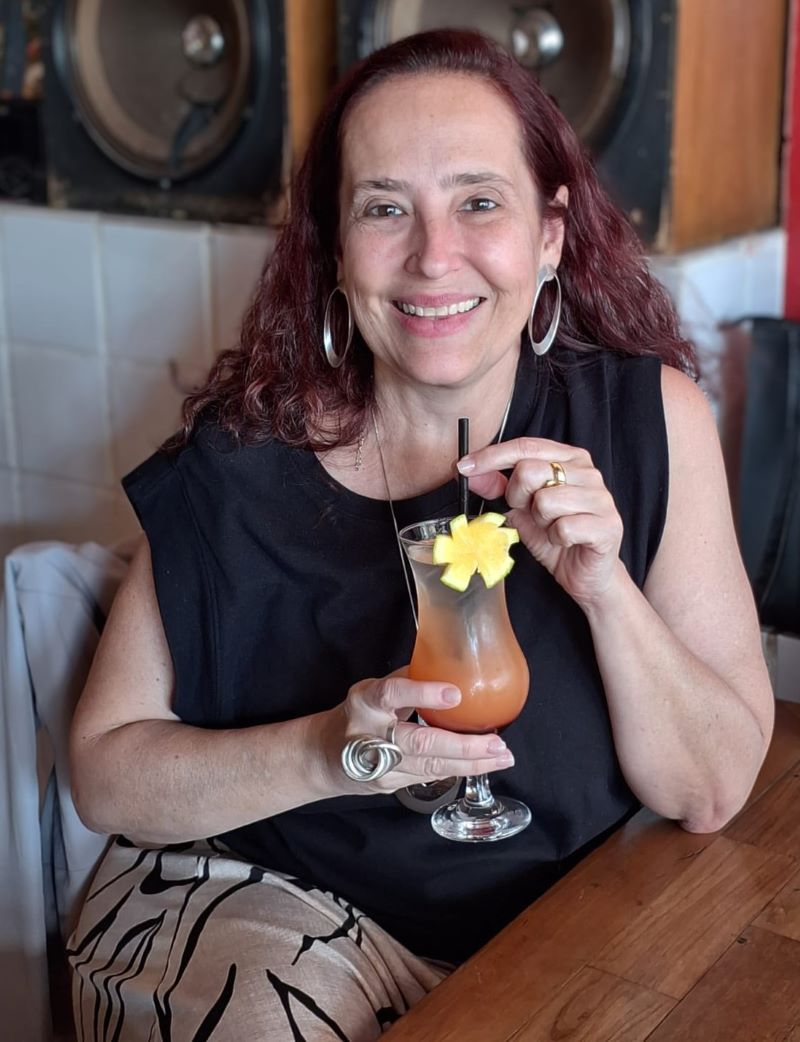 Foto da Alessandra sentada com um coquetel