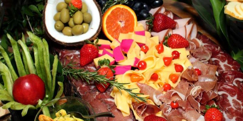 Prato com queijo, presunto e frutas coloridas