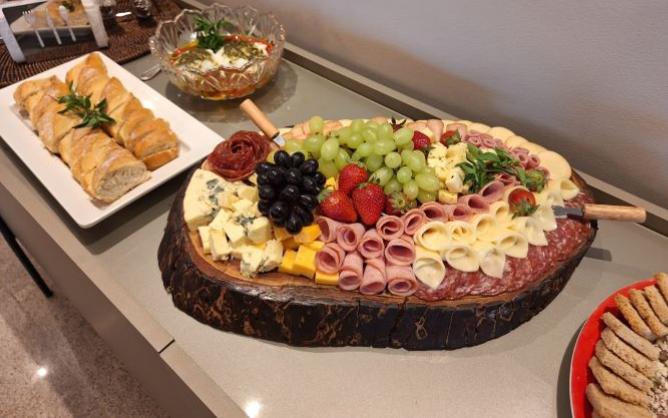 Tabua de madeira com frios diversos, queijos, presuntos, uva e morango